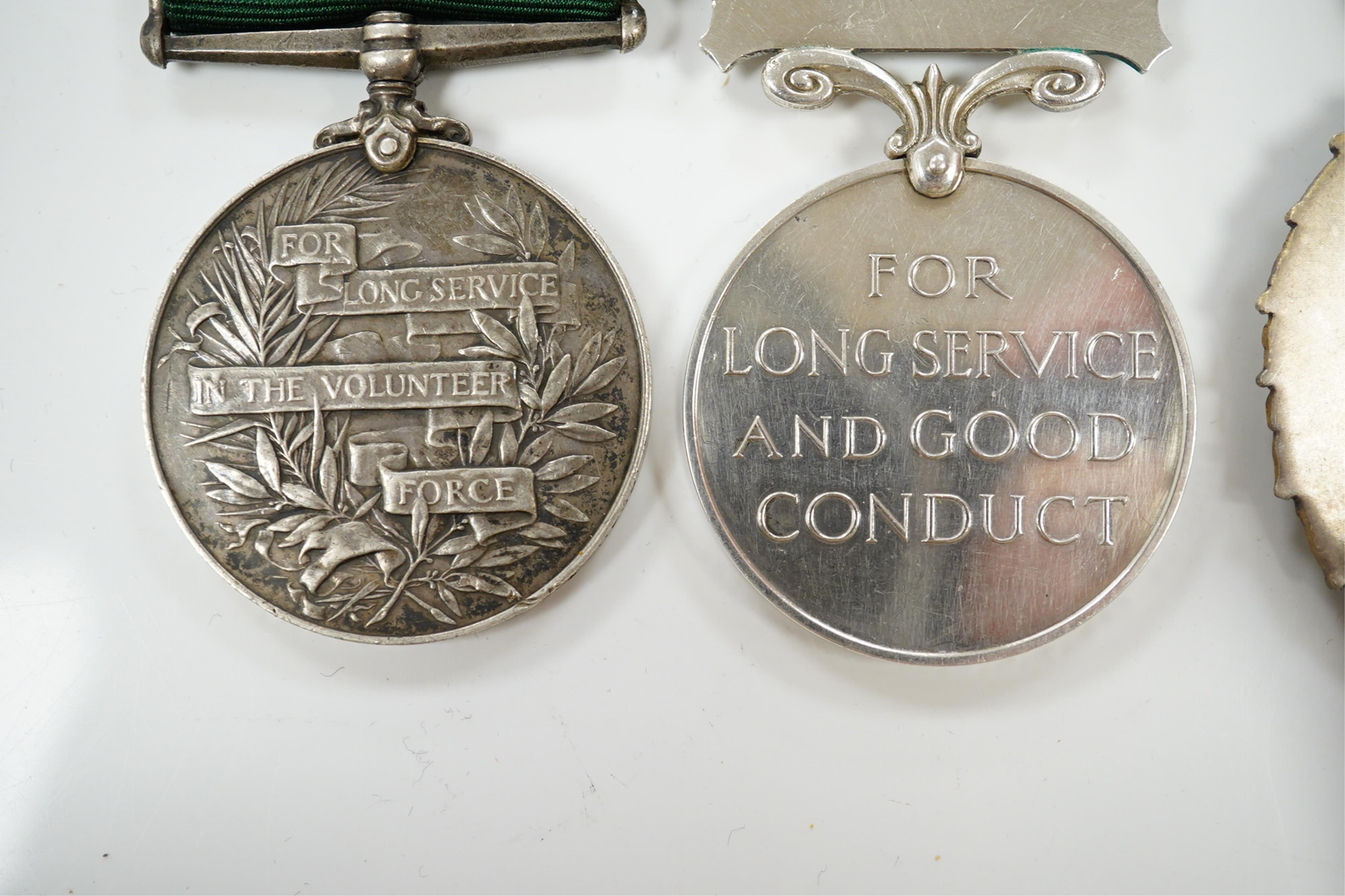 Four assorted service medals; Volunteer Officer's Decoration, hallmarked for 1892; EdVII Volunteer Long Service Medal to 3648 Pte W.Austin I/V B:Lanc:Fus; GV Imperial Service Medal to Frederick Allan Heselwood & Gv Regul